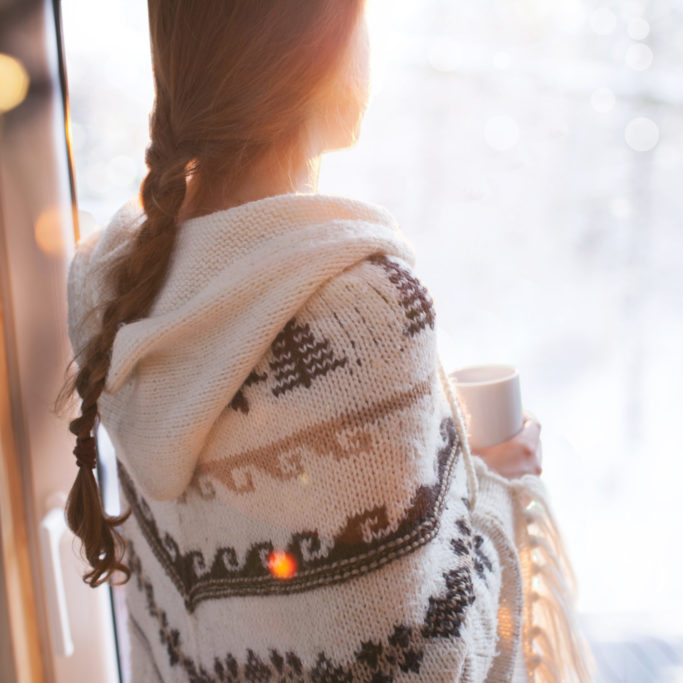 Thoughtful young brunette woman wearing nordic print poncho look